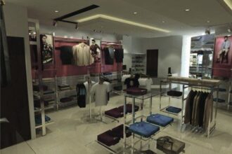 John Players showroom render: clothing racks and display tables under a lit ceiling cove.