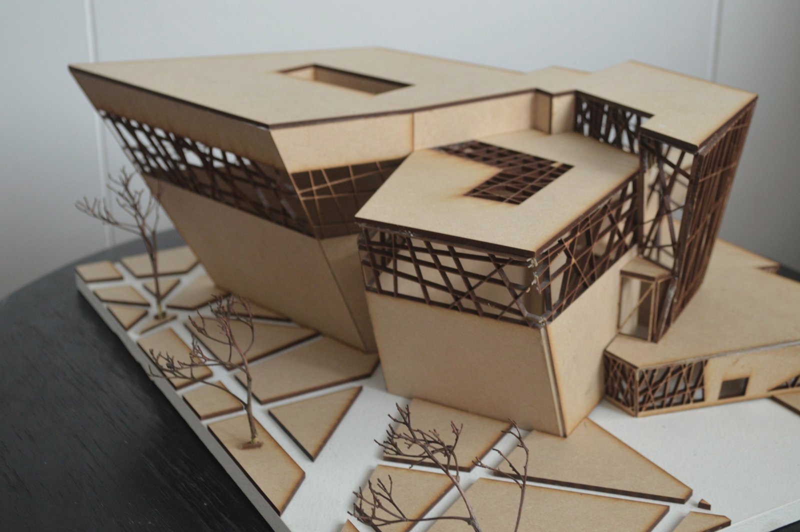 Study model from above at an angle, showing the folded roofs and the angled paving pattern of the site.